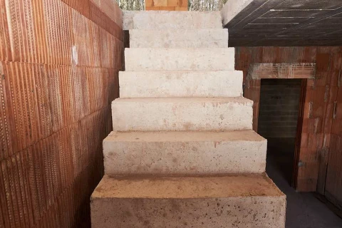 Chantier de construction intérieur avec escalier en béton brut en cours de finition