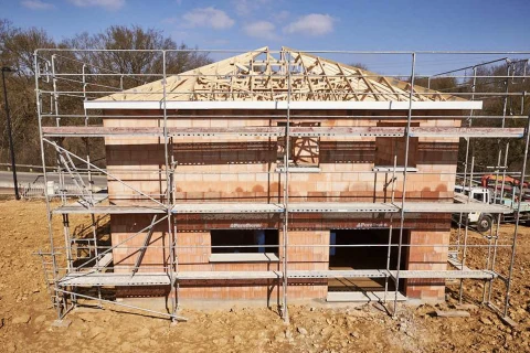 Chantier de construction résidentielle en extérieur montrant une maison individuelle en cours d'édification