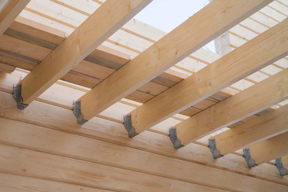 Installation de poutres en bois pour la construction du système de truss de toit de la maison