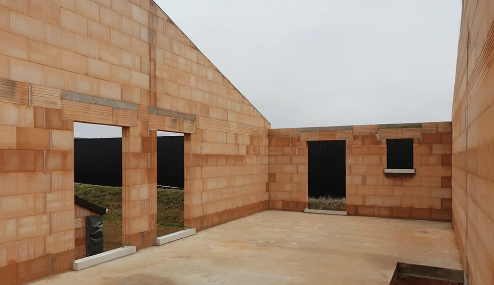 Scène extérieure résidentielle avec maison contemporaine grise à toiture tuiles et garage ouvert