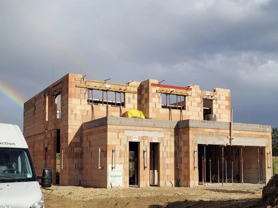 Scène extérieure résidentielle avec maison contemporaine grise à toiture tuiles et garage ouvert