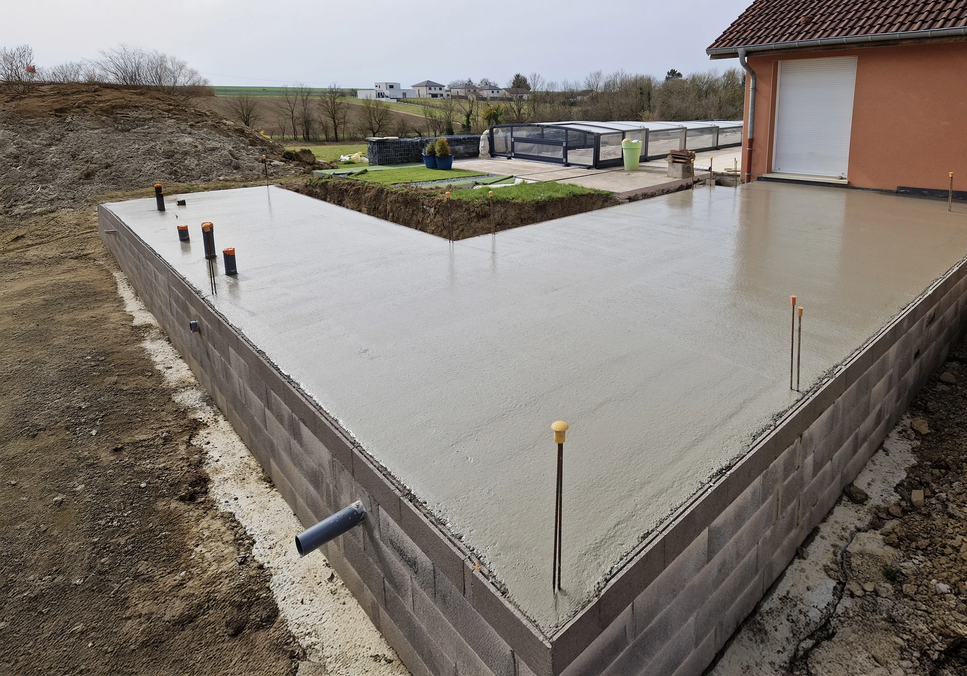 Chantier de construction extérieur avec ouvrier posant des briques