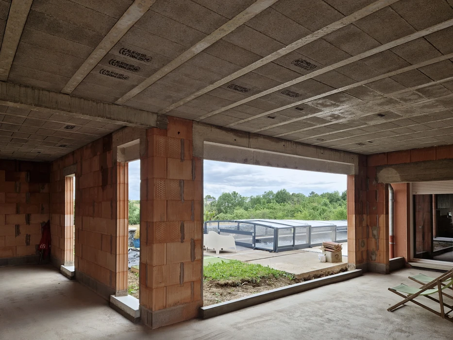 Scène extérieure résidentielle avec maison contemporaine grise à toiture tuiles et garage ouvert