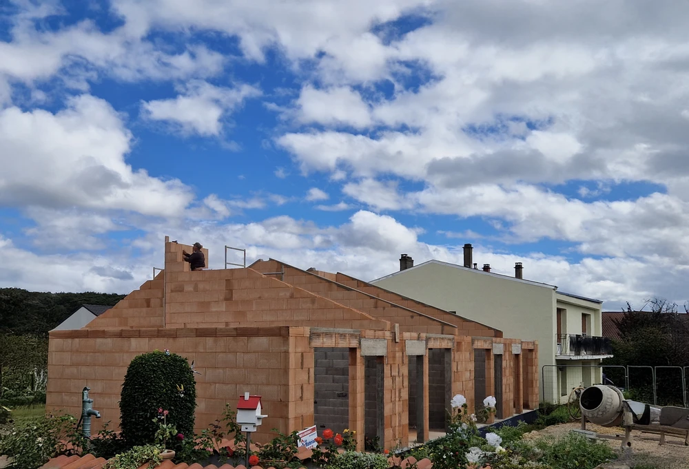 Scène extérieure résidentielle avec maison contemporaine grise à toiture tuiles et garage ouvert